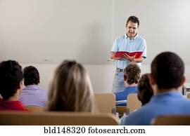 Hispanic college students listening to teacher in classroom