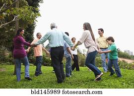 Hispanic family holding hands in a circle outdoors