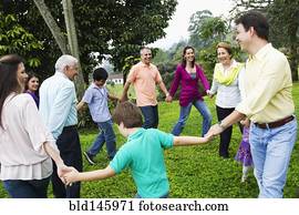 Hispanic family holding hands in a circle outdoors