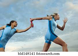 Runners passing baton in relay race