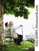 Senior Hispanic couple sitting on park bench Senior Hispanic couple sitting on park bench
