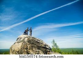 Caucasian climbers standing on rock formation