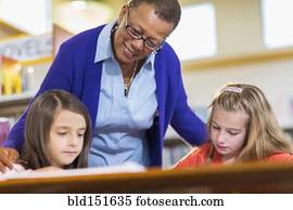 Teacher helping students in library