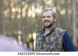 Caucasian man wearing camouflage vest outdoors