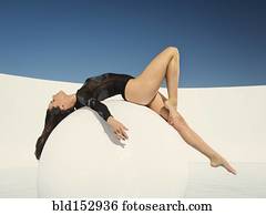 Caucasian woman laying on sphere