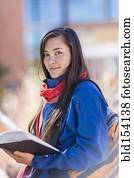 Mixed race student holding books on campus Mixed race student holding books on campus