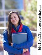 Mixed race student holding books on campus Mixed race student holding books on campus