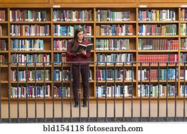 Mixed race student reading in library