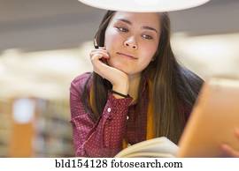 Mixed race student reading in library