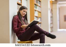 Mixed race student reading in library