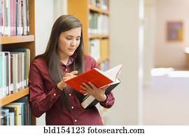 Mixed race student reading in library