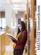 Mixed race student reading in library