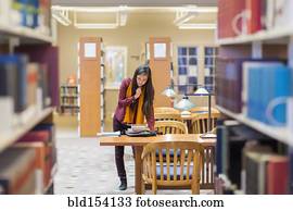 Mixed race student reading in library