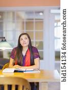 Mixed race student reading in library