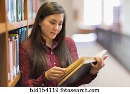Mixed race student reading in library