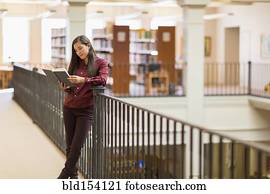 Mixed race student reading in library