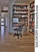 Empty desk and bookshelves in natural healing clinic office