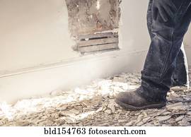 Hispanic construction worker standing in rubble of wall