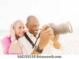 Older couple photographing on beach