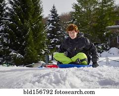 caucasiano, menino adolescente, sledding, ligado, nevado, colina