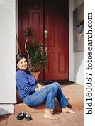 Barefoot woman sitting on front stoop