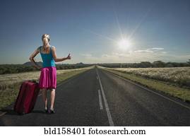 Caucasian woman hitchhiking on remote road