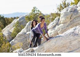 Hikers climbing rocky hillside