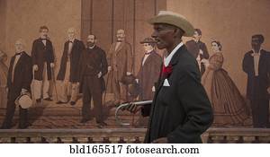 Hispanic man walking past mural, Havana, Cuba