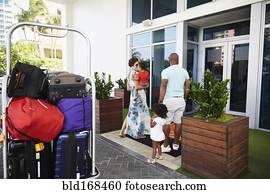 Black family walking into hotel lobby