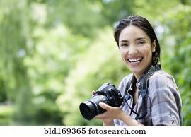 Hispanic woman photographing outdoors