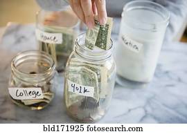 Mixed race woman saving money in jars Mixed race woman saving money in jars