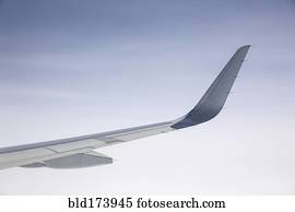 Airplane wing under clear sky