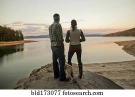 Couple and dog admiring remote lake