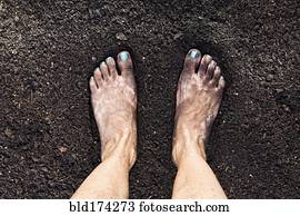 Mixed race woman barefoot in dirt