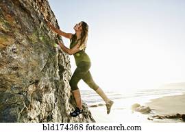 Woman climbing rock formation