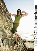 Woman climbing rock formation