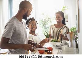 Black family cooking in kitchen