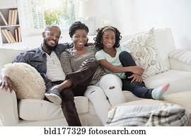 Black family smiling on sofa