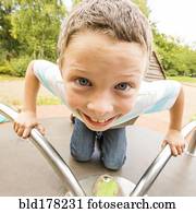 Caucasian boy playing on merry-go-round
