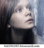 Caucasian woman standing at wet glass