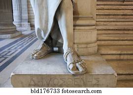 Close up of feet of carved statue on marble pedestal