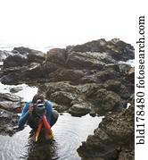 Hispanic diver photographing on beach