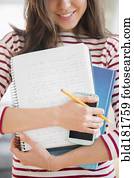 Mixed race student holding homework and cell phone Mixed race student holding homework and cell phone