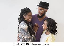 Smiling Black family hugging