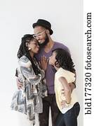 Smiling Black family hugging