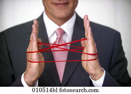 businessman doing the cat′s cradle with a red woolen thread businessman doing the cat′s cradle with a red woolen thread