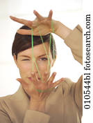 joven, mujer de negocios, mirar completamente, el, verde, hilo, mientras, hacer, el, cat´s, cuna