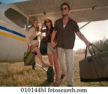 one man and two women posing like fashion models near small propeller plane one man and two women posing like fashion models near small propeller plane