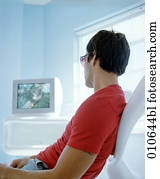 yong, hombre, en, camiseta roja, mirando tele