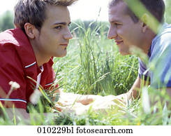 Two young gay men (20-25 years) in the park holding hands 